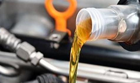 Fresh motor oil being poured into an engine